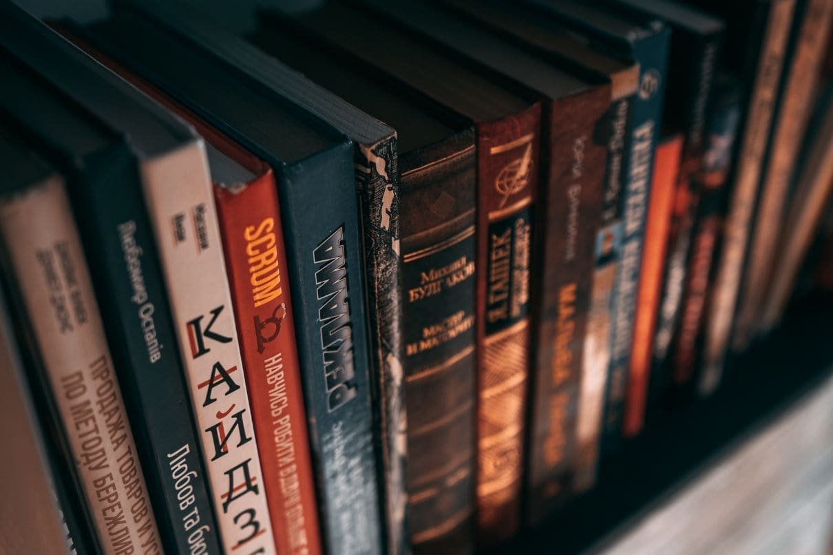 A row of books neatly arranged on a shelf, showcasing various titles and colors